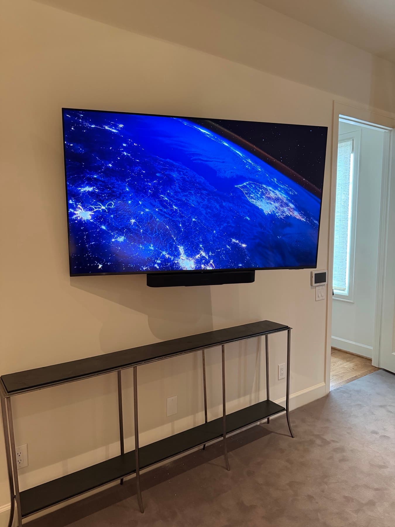 Cleanly wall-mounted television with a Sonos soundbar in a River Oaks home